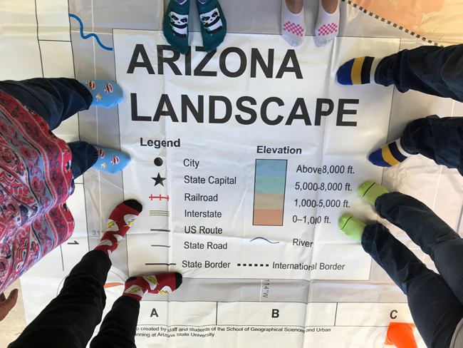 Picture of people's feet on a giant Arizona Landscape map